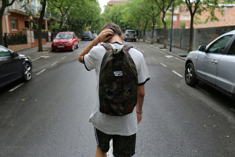 Estudiante caminando por la calle en horario lectivo ilustrando el absentismo escolar y sus consecuencias.