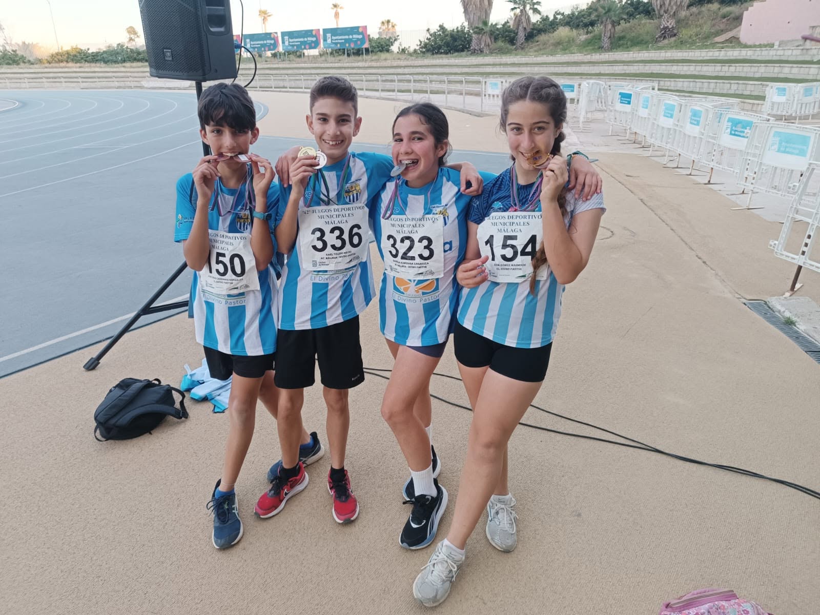 Jóvenes atletas entrenando en la pista de atletismo en Málaga durante sus clases extraescolares para adolescentes.