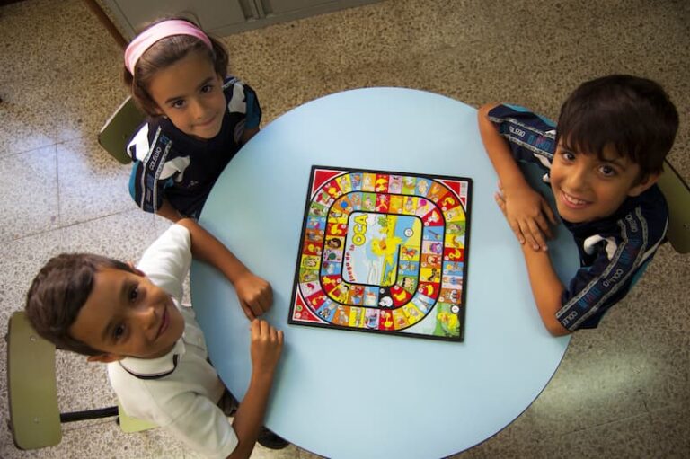 Niños jugando a un juego de mesa durante el aula matinal en el Colegio El Divino Pastor de Málaga, fomentando la conciliación familiar y laboral.