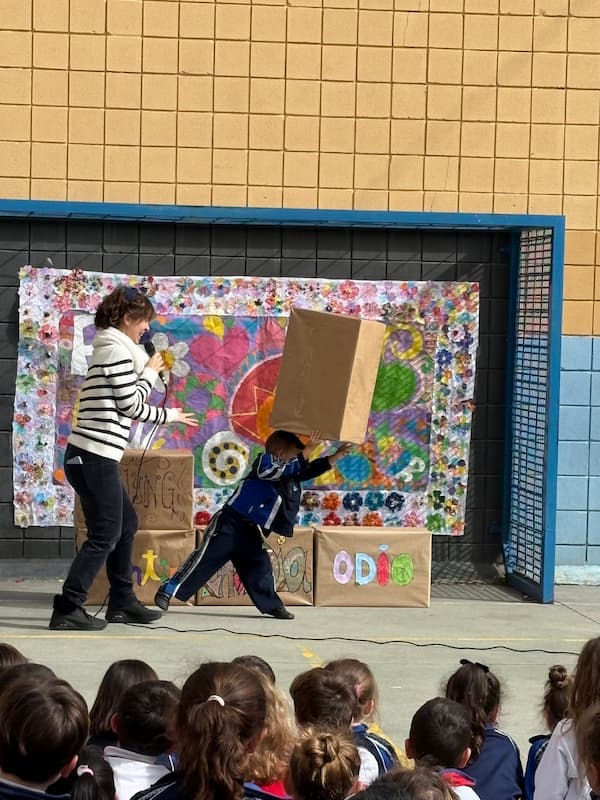 Alumno y profesora derribando el muro del odio durante el Día de la Paz en infantil en nuestro colegio.