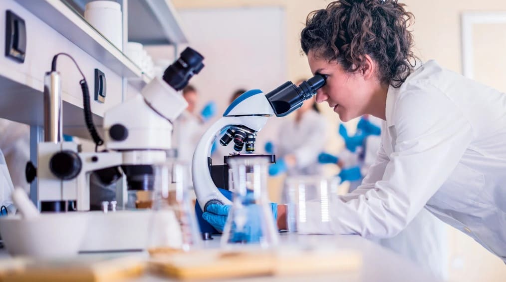 Estudiante de FP Laboratorio Clínico y Biomédico en Málaga realizando prácticas como técnico de laboratorio con microscopio en el grado superior de formación profesional.