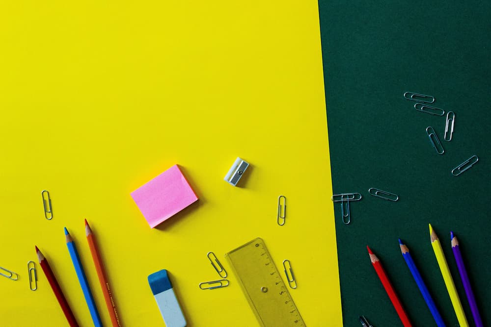 Material de escritorio y papelería escolar sobre fondo de colores para la vuelta al colegio en Málaga.